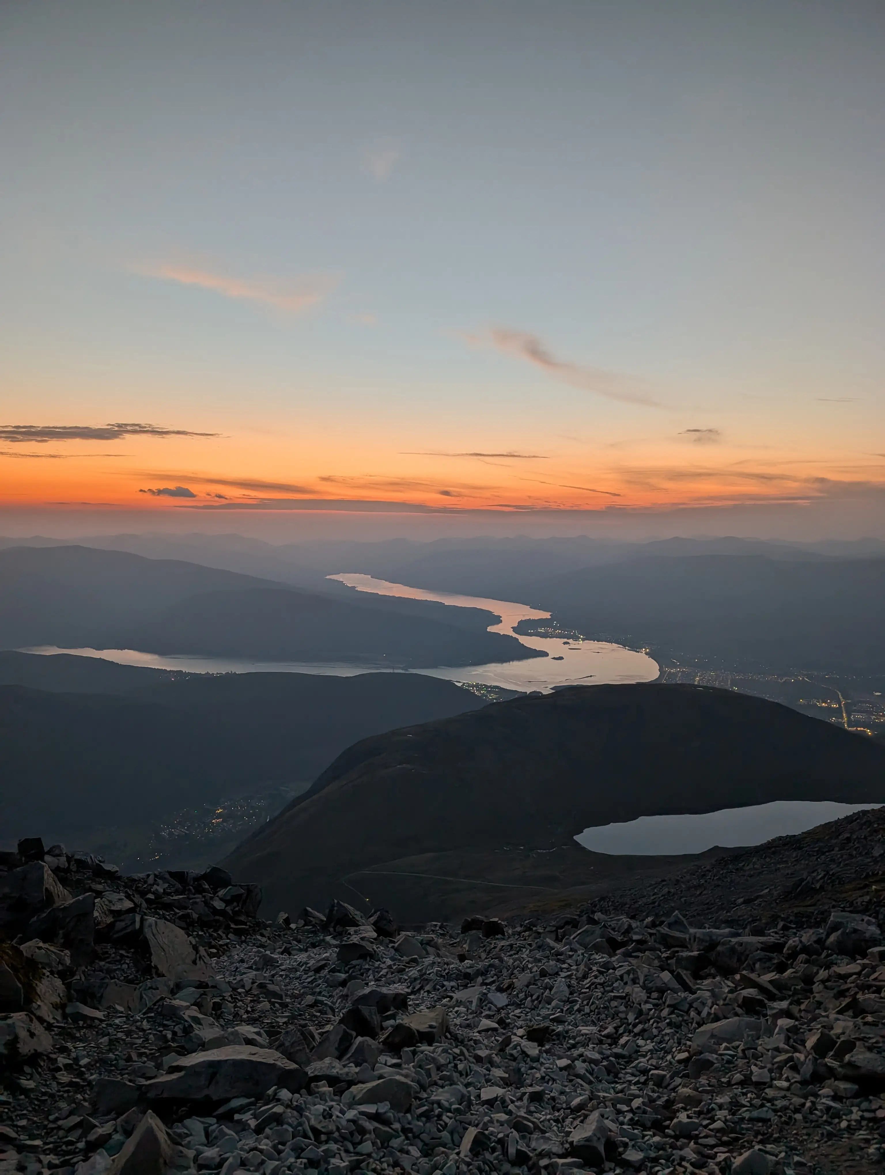 Serene editorial photograph from Ben Nevis Mountain Summit, capturing the sunset, Fort William, Loch Eil, Clovullin, Ardgour Mast, Seal Rock, Corpach, Loch Shiel, Loch Sunart, Garbh Bheinn and Creach Bheinn